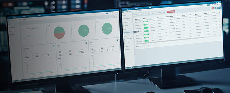 Um espaço de trabalho escuro com dois monitores exibindo painéis e gráficos de análise de dados.